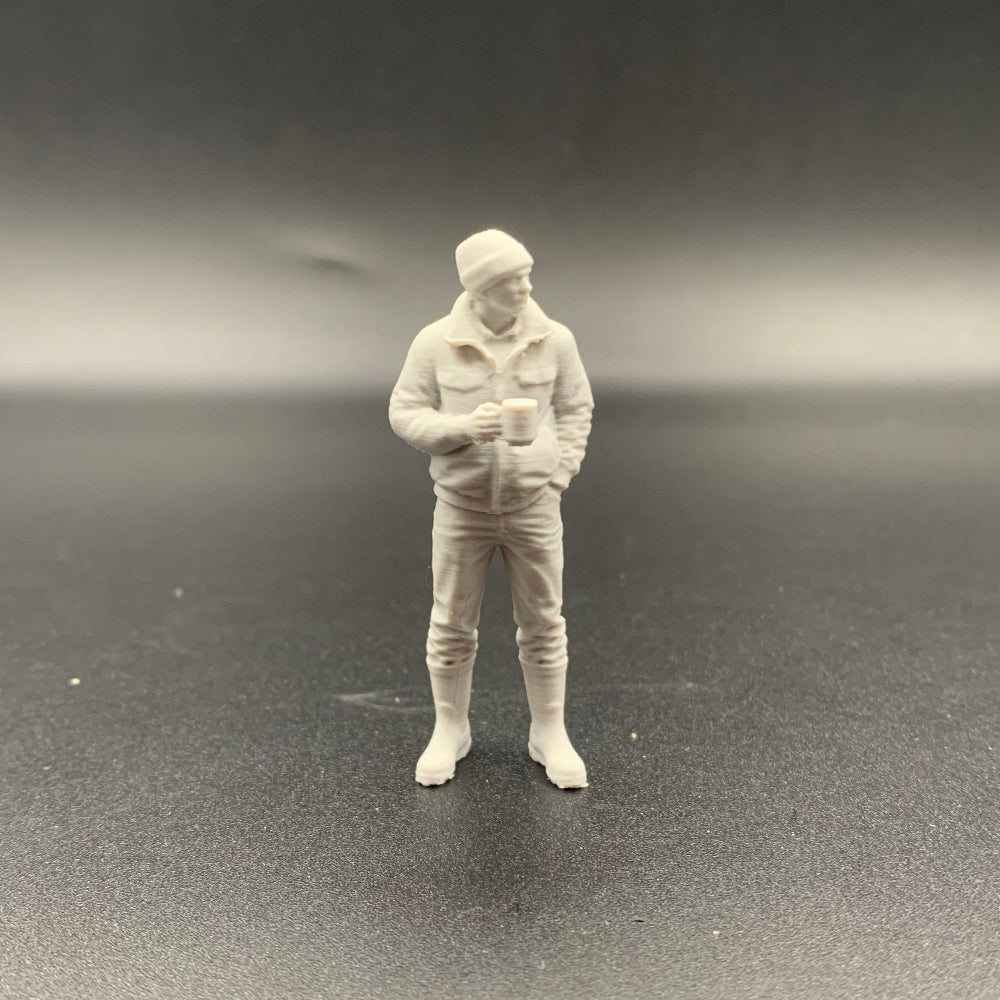 3D printed crew figure holding a mug with one hand and standing casually with the other hand in his pocket
