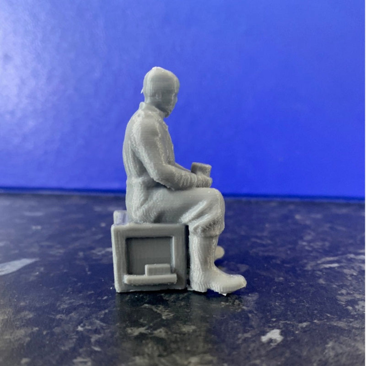 Side view of unpainted grey 3D printed trawler fisherman figure wearing waterproof jacket, boots, and hat model Boat crew figure