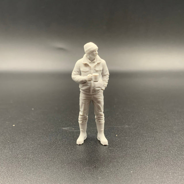 3D printed crew figure holding a mug with one hand and standing casually with the other hand in his pocket